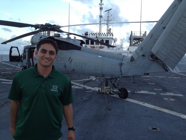student poses with Navy Helicopter