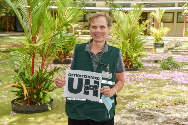 Kristine Qureshi with a sign Get Vaccinated UH