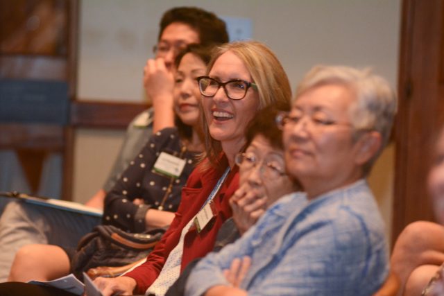 Audience members at a lecture listening