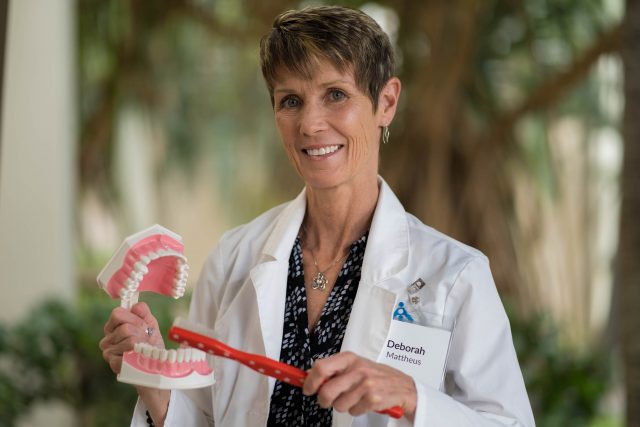 Deborah Mattheus with a model mouth and tooth brush