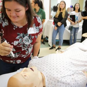 High School Student Participates In Nursing Simulation With Dummy Patient
