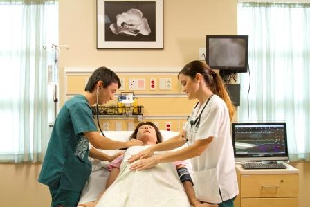 Male and female nursing student with manikin in UH Translational Health Science Simulation Center.