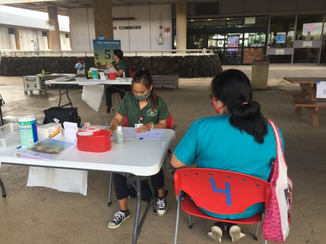 Nursing student checking forms and preparing to vaccinate